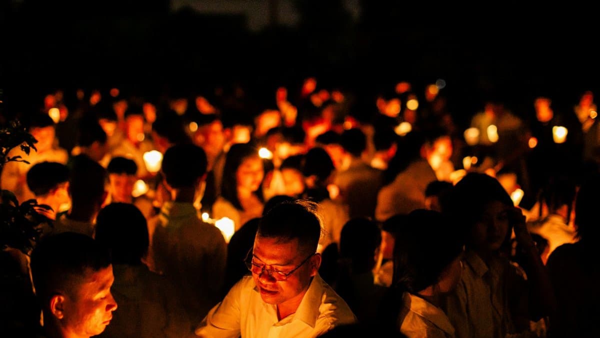 A peaceful candlelight vigil at night with people holding candles, symbolizing unity and hope.