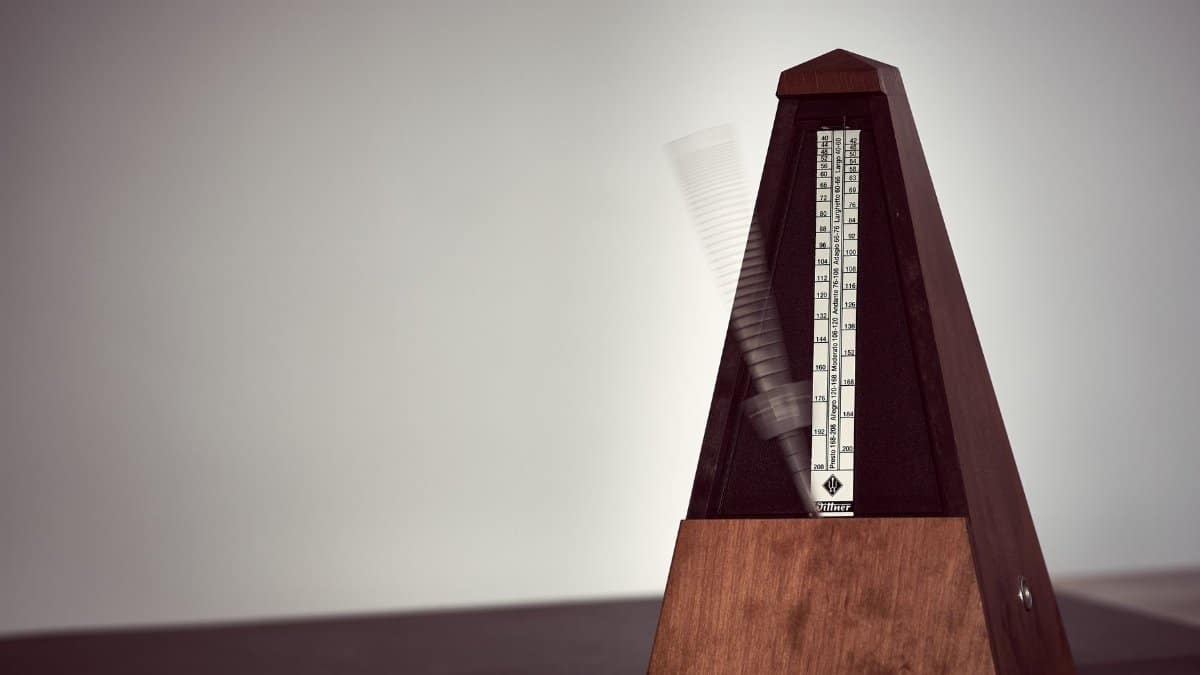A close-up image of a wooden metronome in motion, symbolizing precision in music practice.