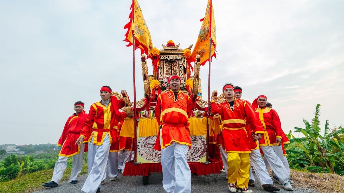 Vibrant cultural festival procession with participants in traditional attire, outdoors.