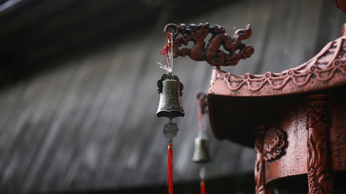 Close-up of a hanging temple bell with dragon designs, showcasing traditional artistry.