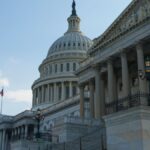 Classic view of the historic US Capitol Building in Washington, DC, with a clear blue sky.