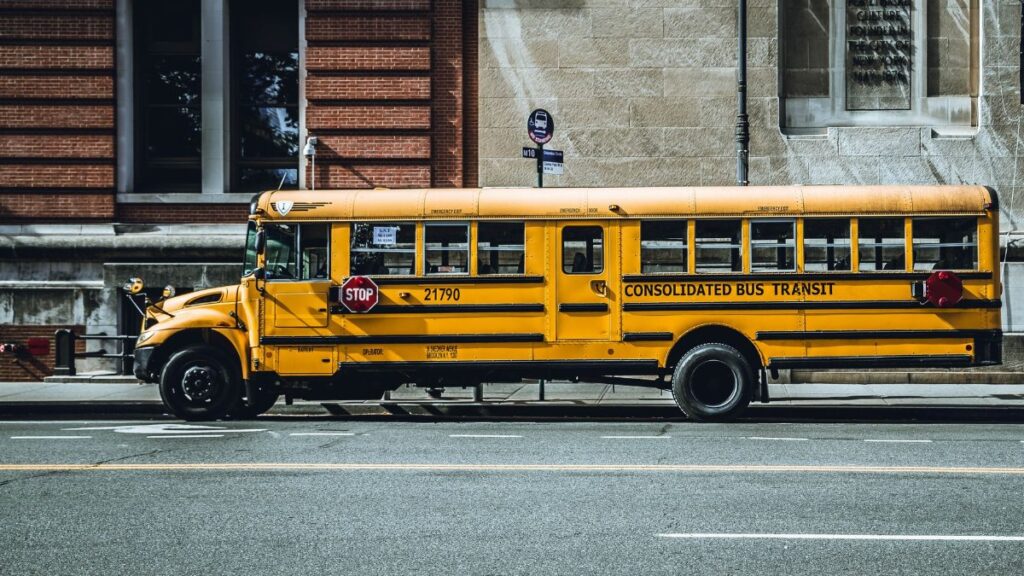 Yellow school bus parked in urban New York City street, showcasing iconic American transportation.