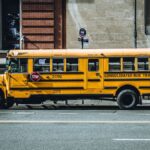 Yellow school bus parked in urban New York City street, showcasing iconic American transportation.