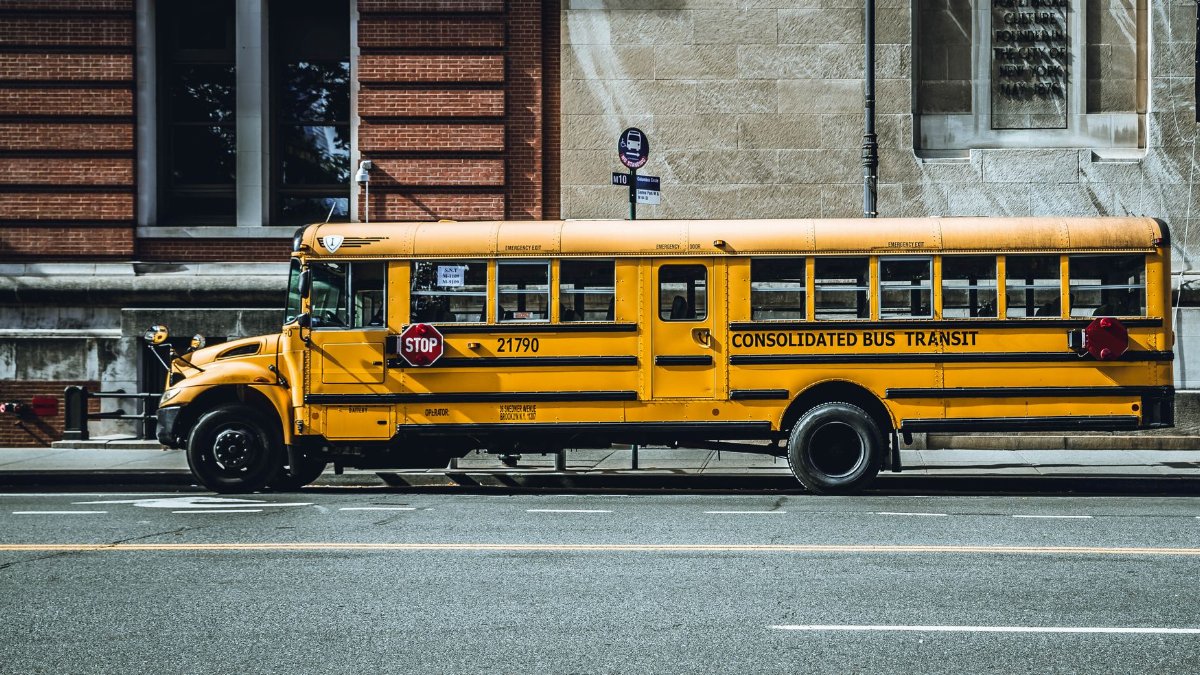 Yellow school bus parked in urban New York City street, showcasing iconic American transportation.