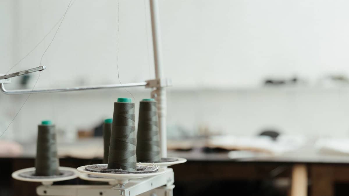 Detailed view of thread spools in a sewing workspace, highlighting precision craft tools.