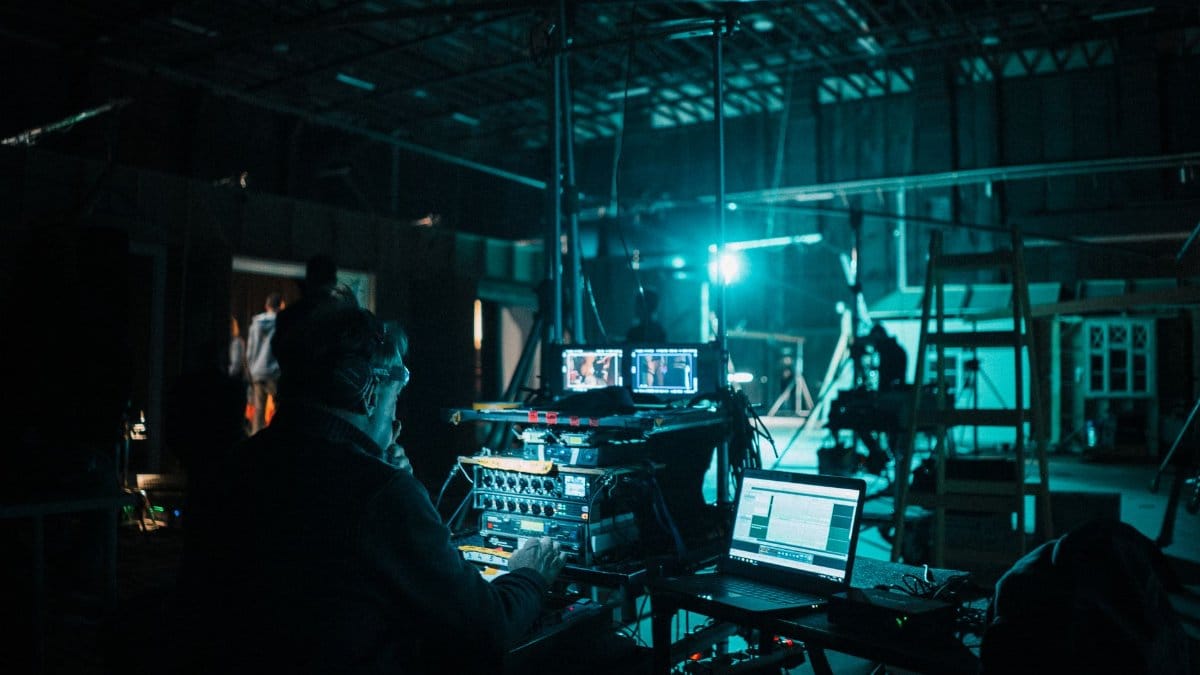 Film crew operating technical equipment on a dimly lit set in Budapest, Hungary.