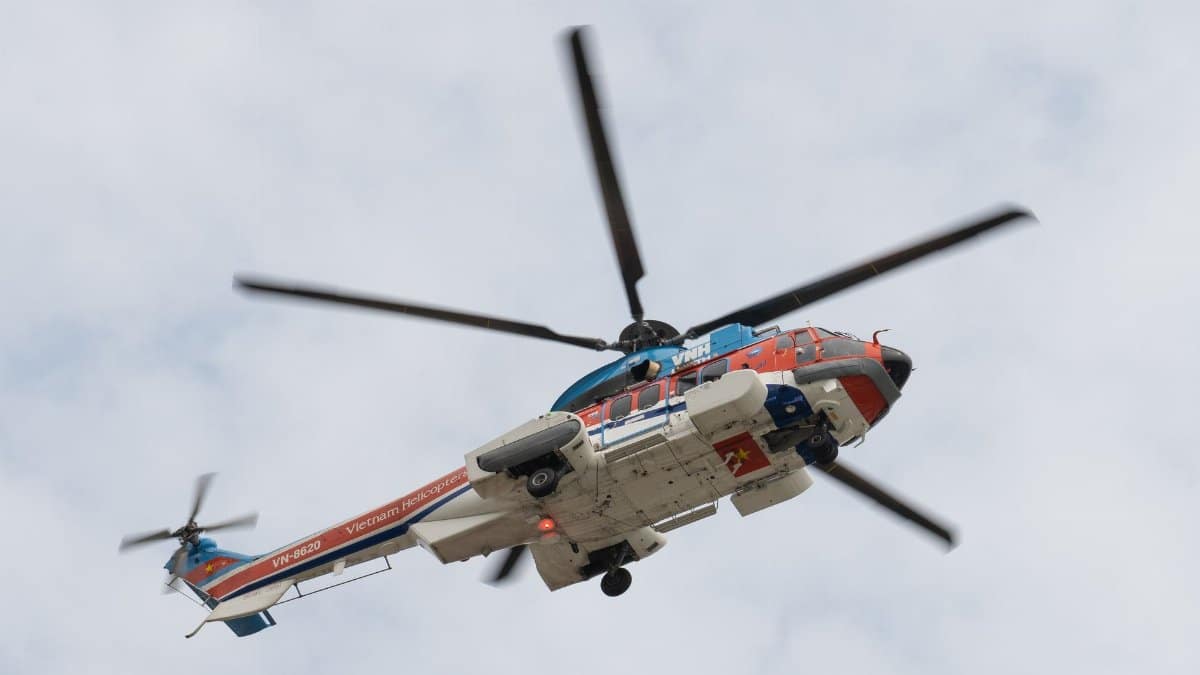 A colorful helicopter soaring through a cloudy sky, showcasing Vietnam's aviation technology.