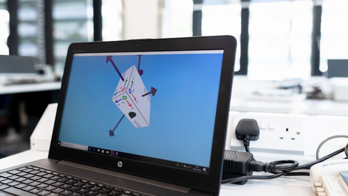 Laptop in an office environment displaying 3D design software on screen, emphasizing technology and creativity.