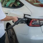 Electric car being charged at a station, highlighting eco-friendly transportation.