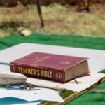 Outdoor table setup with a Teacher's Bible and microphone. Ideal for educational or religious themes.