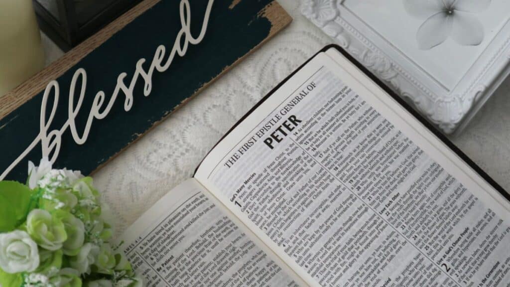 Top view of an open Bible with a 'blessed' sign and floral decor, conveying a serene and spiritual atmosphere.