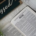 Top view of an open Bible with a 'blessed' sign and floral decor, conveying a serene and spiritual atmosphere.
