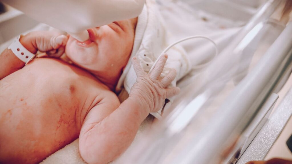 A newborn baby in a hospital setting receiving care with a focus on wellness and health.