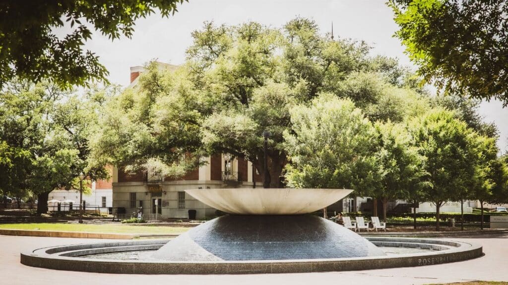 Scenic view of Rosenbalm Fountain surrounded by trees on a sunny day at Baylor University campus, Waco, Texas.
