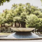 Scenic view of Rosenbalm Fountain surrounded by trees on a sunny day at Baylor University campus, Waco, Texas.