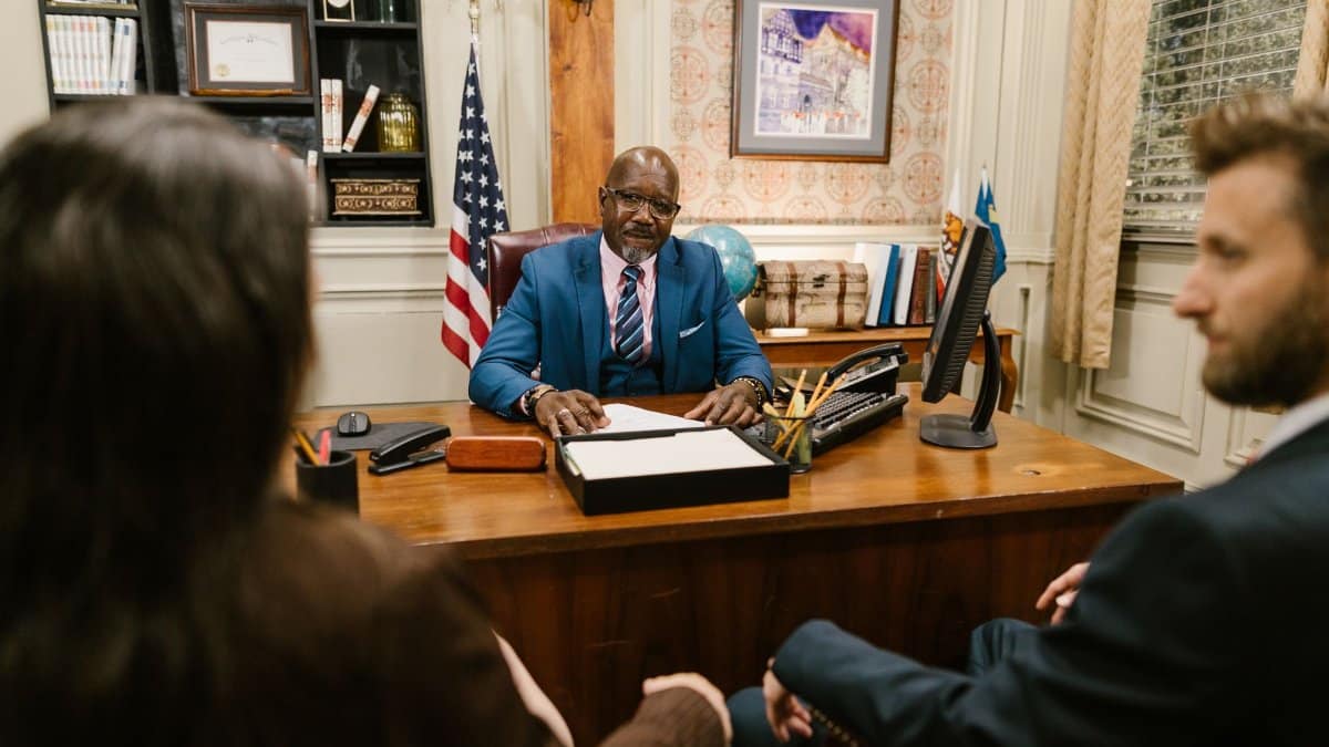 A professional lawyer meeting with clients in his office at a legal consultation.