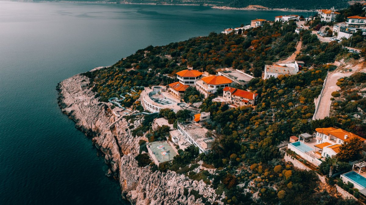 Stunning aerial view of cliffside villas along the Mediterranean coast in Antalya, Türkiye.