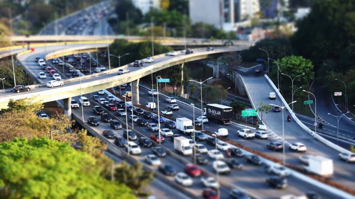 Dense traffic on a multi-level urban highway with tilt-shift effect, showcasing an intricate transportation system.