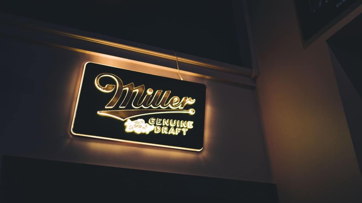 A glowing Miller Genuine Draft neon sign casting warm light indoors, perfect for bar or pub ambiance.