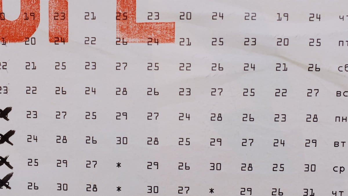 Abstract calendar banner with numbers printed in rows and days of week aside placed on wall on street