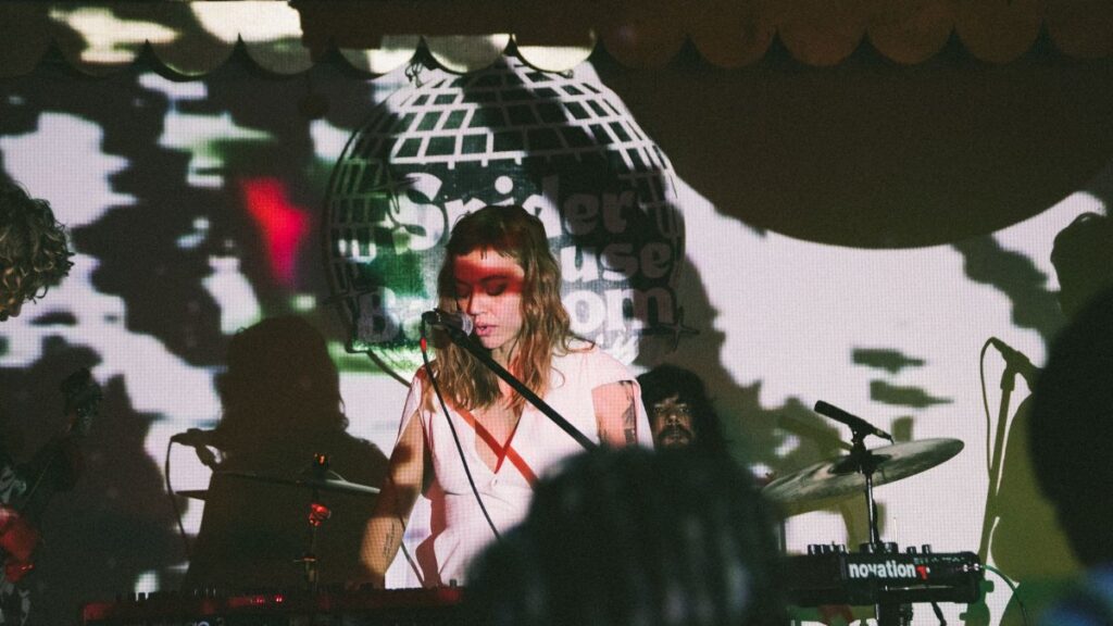 A captivating live music performance featuring a female musician with dramatic shadow effects on stage.