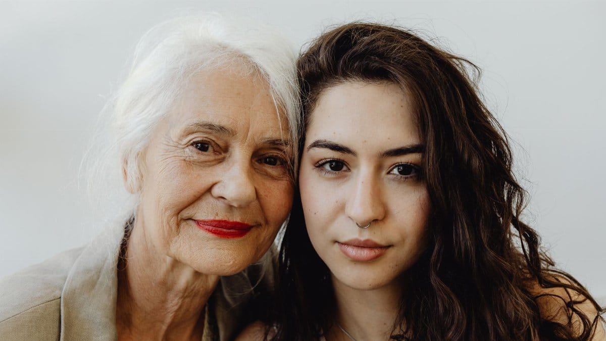 Elegant portrait of a grandmother and granddaughter looking directly at the camera, capturing their bond.