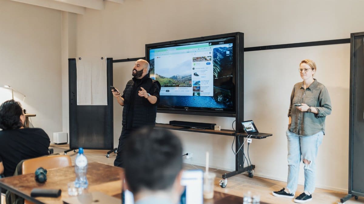 A team presentation in an office with a screen showcasing work-related material.