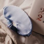 A soft blue sleep mask and 2021 planner on a quilted bedspread create a serene setting.