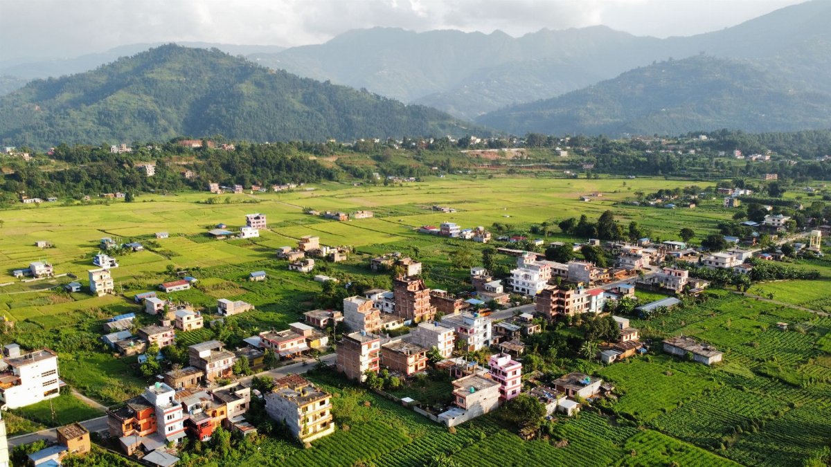Aerial view of Bidur, Nepal showcasing lush greenery, mountains, and village settlements.