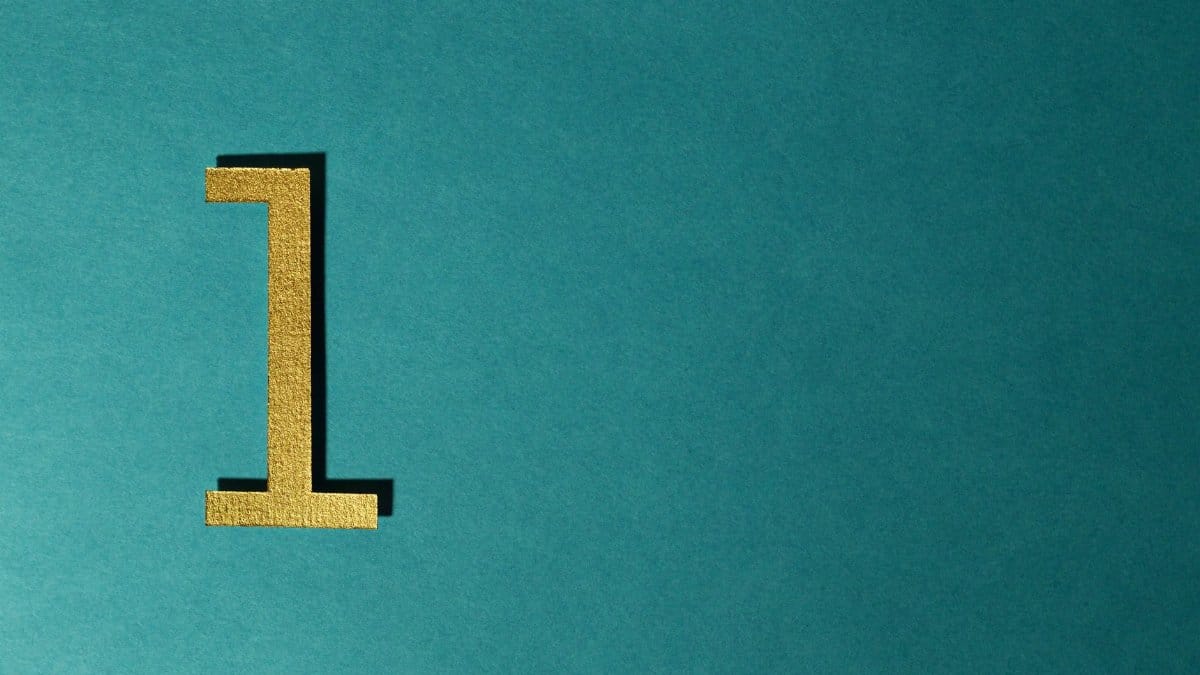 A gold number one on a teal background with ample copy space.