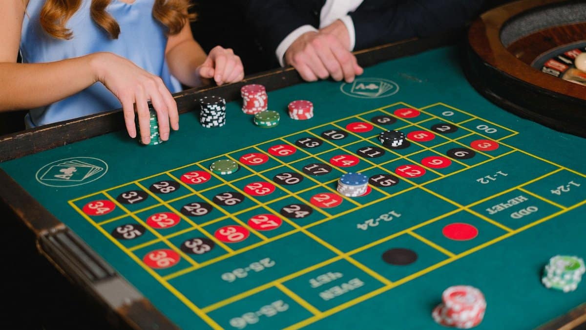 Captivating scene of a casino roulette table with gamblers placing their bets.