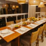Warm and inviting dining room with wooden table, woven chairs, and ambient lighting, ready for a formal dinner.