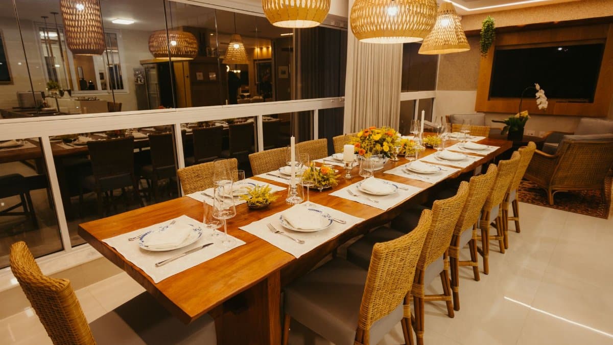 Warm and inviting dining room with wooden table, woven chairs, and ambient lighting, ready for a formal dinner.
