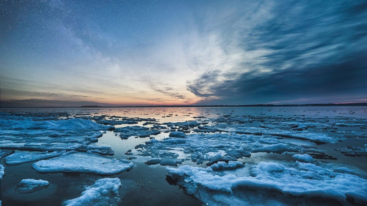 A breathtaking view of icy formations under a starry sky at sunset in Traverse City, Michigan.