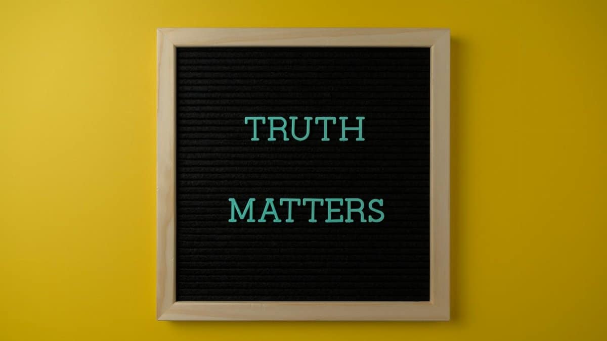 Close-up of black letter board with 'Truth Matters' message on yellow background.