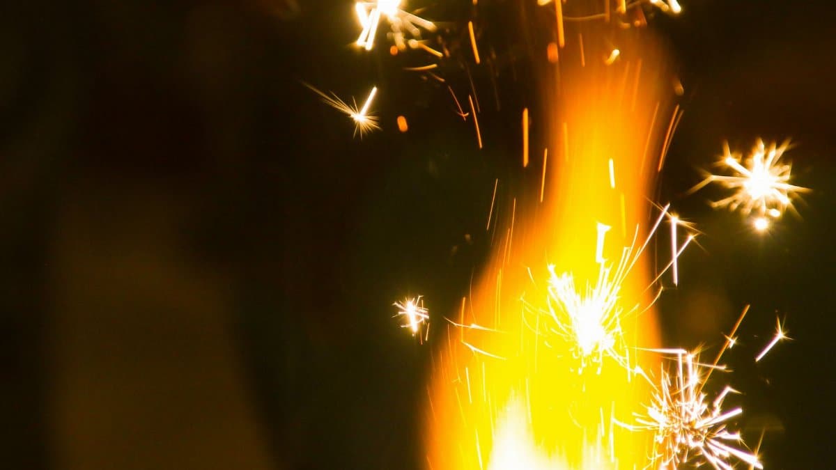 Captivating close-up of fireworks with bright sparks illuminating the dark night.