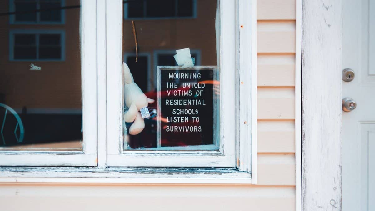 Sign in window mourns victims of residential schools. Support survivors.