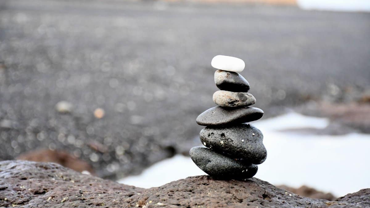 Peaceful beach scene featuring a stack of smooth stones, symbolizing balance and tranquility.
