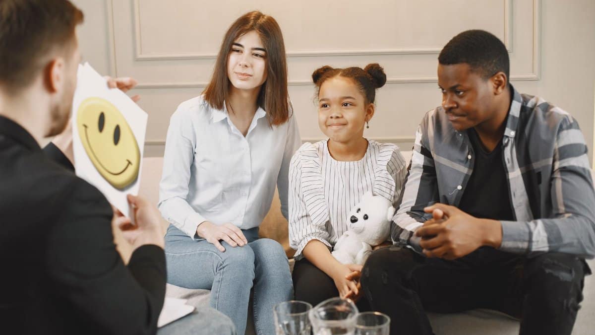 A family therapy session with a therapist, featuring parents and a child engaging in discussion.