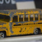 Close-up of a vintage toy school bus in yellow with a distressed finish.