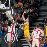 Dramatic moment in a basketball game with players and an engaged crowd.