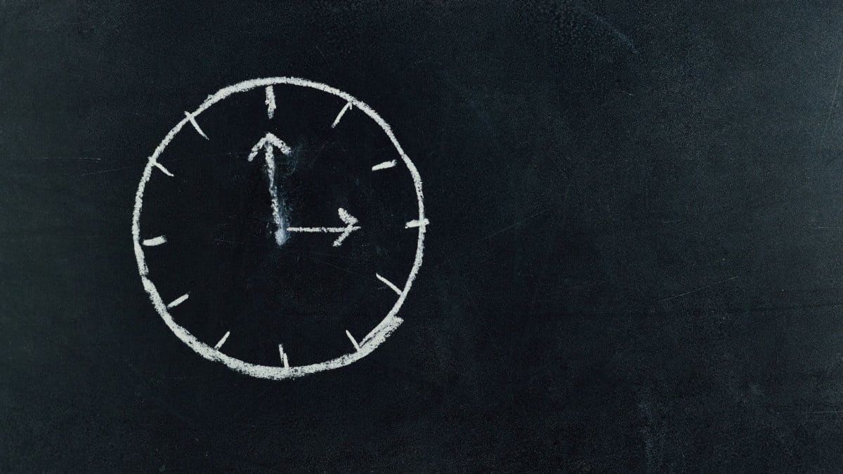 Chalk-drawn clock on a blackboard, symbolizing time and education concepts.