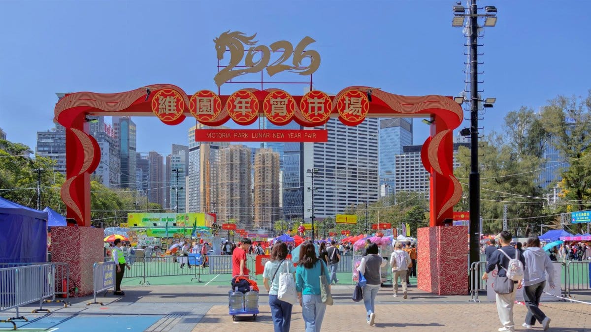 Crowds enjoying the vibrant 2026 Lunar New Year Fair at Victoria Park, Hong Kong under clear blue skies.