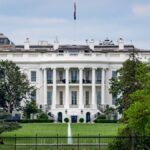 A scenic view of The White House, a renowned landmark in Washington, DC, surrounded by greenery and tourists.