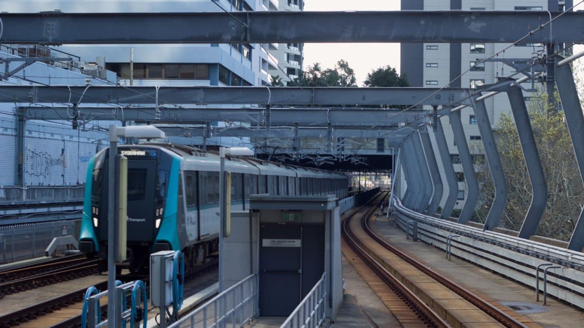 Sydney Metro train entering Chatswood Station in New South Wales, featuring urban architecture.
