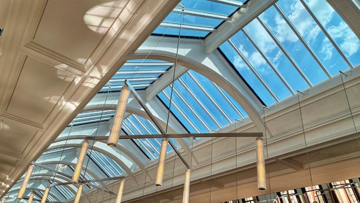 A stunning view of a contemporary hallway with a glass ceiling and bright natural light.