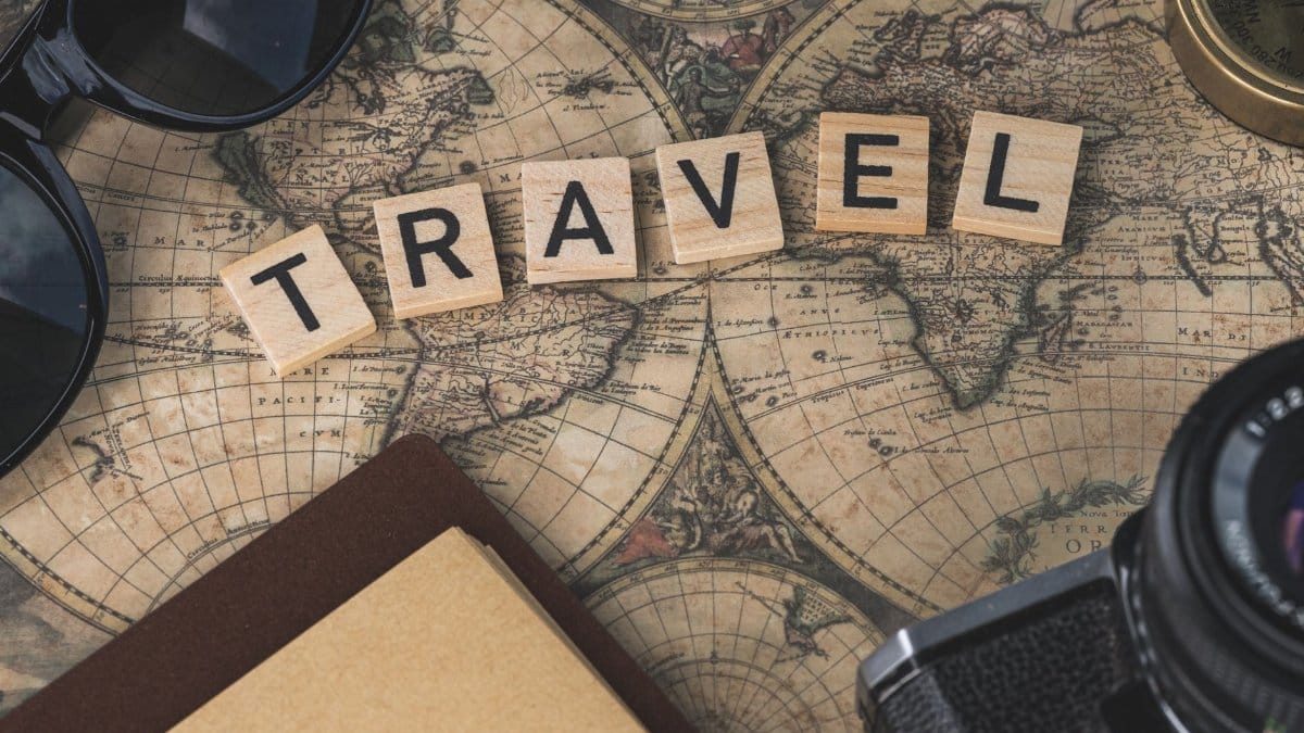 Vintage map with travel essentials like camera and sunglasses arranged in a flat lay, perfect for adventure themes.