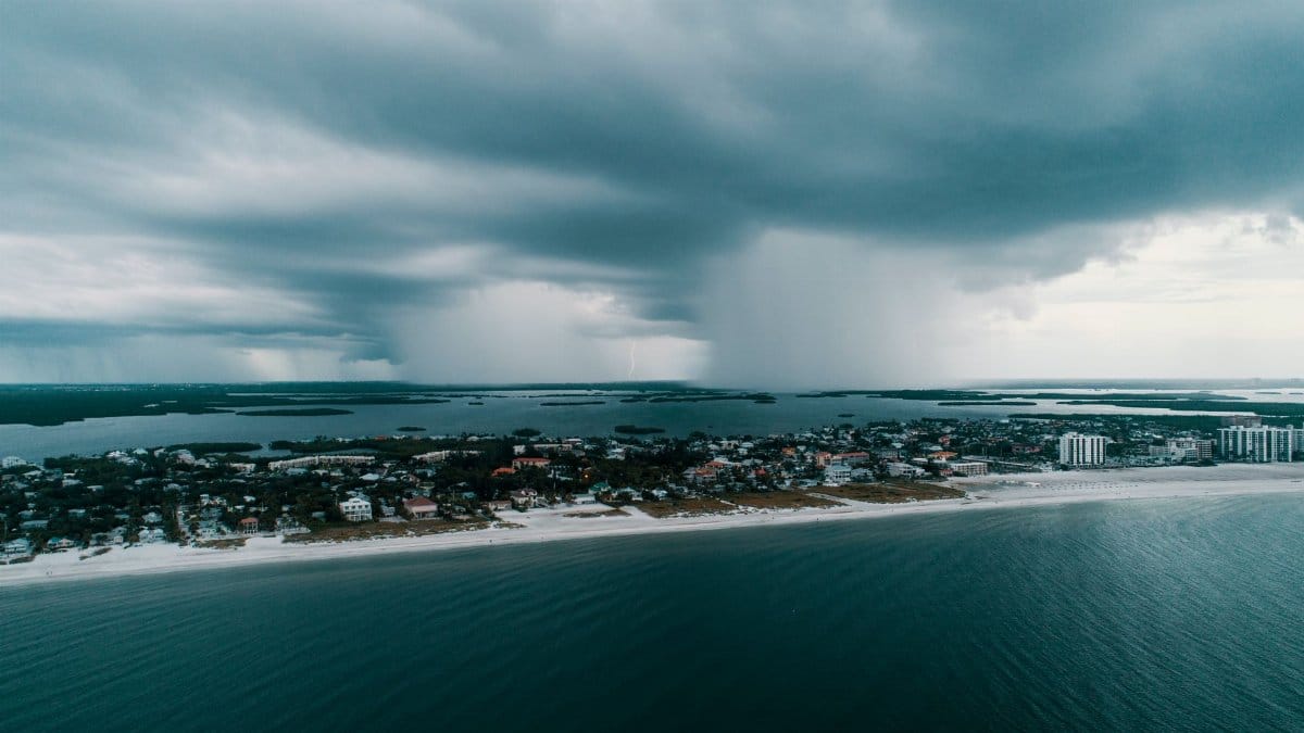 A stunning aerial view capturing a storm approaching an island village along the coast.