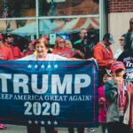 A crowded political rally in Wheeling, showcasing Trump supporters with banners and signs.