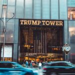 Dynamic view of Trump Tower's entrance with bustling street traffic in New York City.